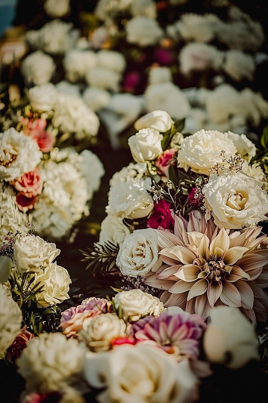 Elegant floral arrangements featuring white roses, vibrant dahlias, and greenery, creating a lush and romantic atmosphere.