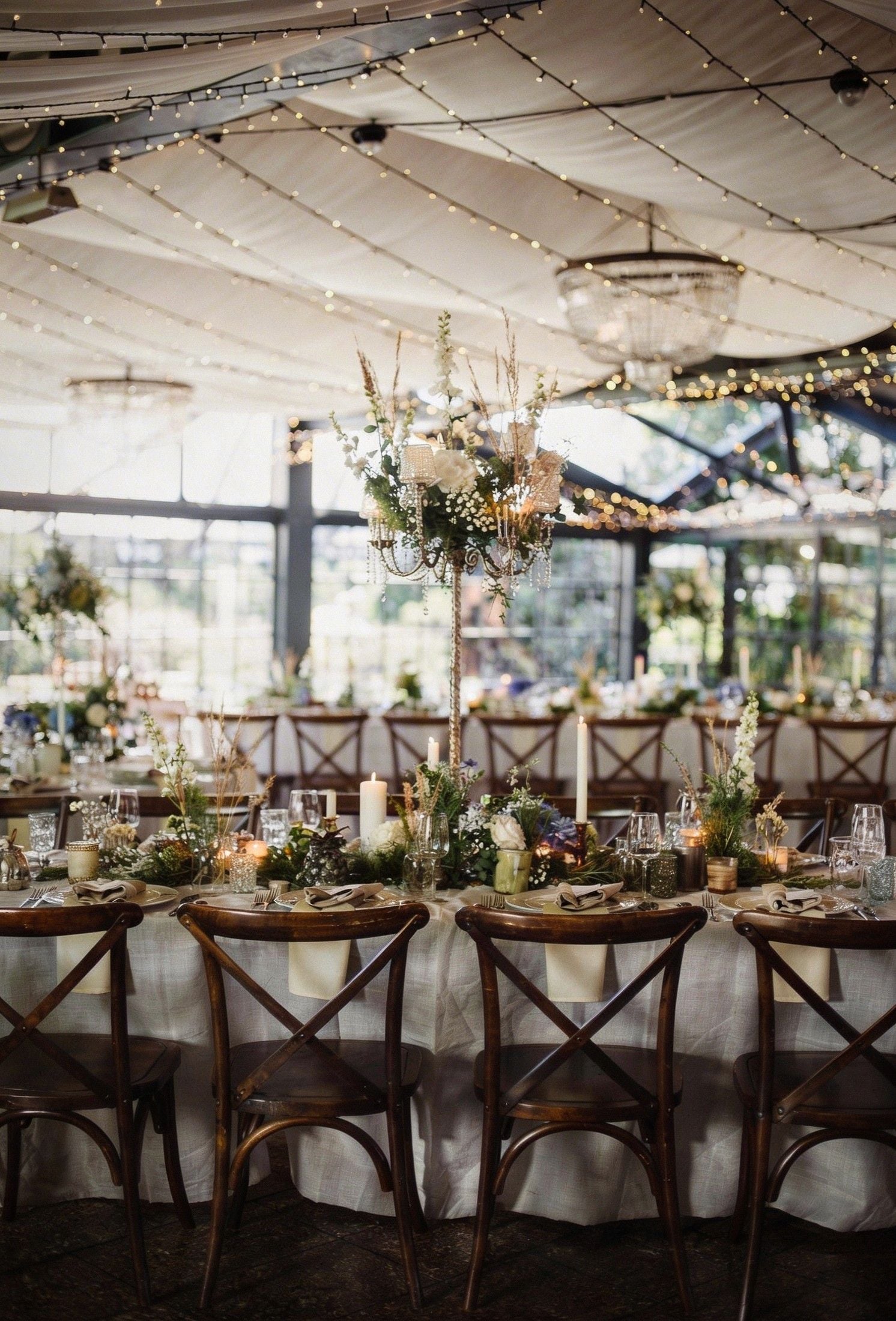 A beautifully decorated wedding reception with elegant tables, floral centerpieces, and warm twinkling lights.
